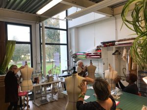 Plusieurs élèves prennent un cours de modelisme pour apprendre à créer leurs propres patronnages, dans la salle dédiée à la Maison de Haute couture FDDL